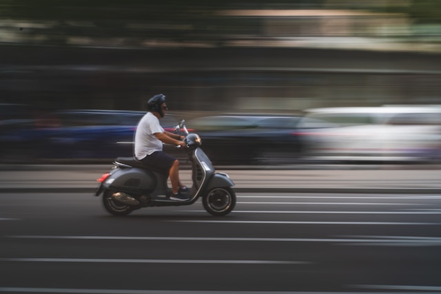 Homme roulant un scooter électrique sur la route