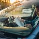 Conducteur consultant des documents d'assurance dans sa voiture
