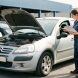 Une Citroën C3 d’occasion sur un parc automobile, contrôlée avant achat par une mécanicienne qui inspecte le compartiment moteur puis observe l’état extérieur.