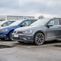 Rangée de voitures d’occasion dans une concession allemande, avec une Golf, une Passat, une Tiguan et une Polo au premier plan.