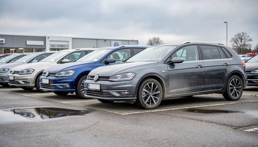 Rangée de voitures d’occasion dans une concession allemande, avec une Golf, une Passat, une Tiguan et une Polo au premier plan.